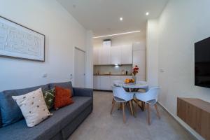 a living room with a couch and a table with chairs at The Simon Residences - Marina Escape in Olhão