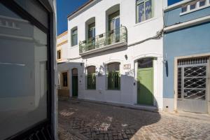 a street view of a building with green doors at The Simon Residences - Marina Escape in Olhão