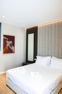 a bedroom with a large white bed and a mirror at Oribu Boutique Hotel Vlore in Vlorë