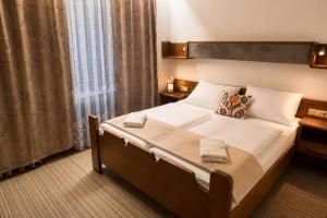 a bedroom with a large bed and a window at Appartements MAGLOV in Bad Kleinkirchheim