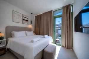 a bedroom with a large white bed and a window at The Simon Residences - Marina Escape in Olhão