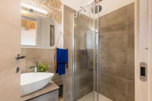ein Badezimmer mit Waschbecken und Glasdusche in der Unterkunft Tra Cale e Rioni in Baunei