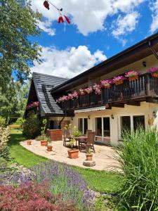 a house with a patio and a balcony with flowers at U Helci - Na Krańcu Świata - Azyl tylko dla Dorosłych in Studzienno