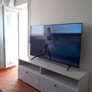 a flat screen tv sitting on top of a dresser at Vila Mar Apartment in Vila do Conde