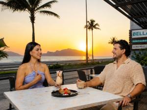 a man and woman sitting at a table with a plate of food at Olas Altas Inn Hotel & Spa in Mazatlán