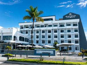 a hotel with a palm tree in front of a building at Olas Altas Inn Hotel & Spa in Mazatlán