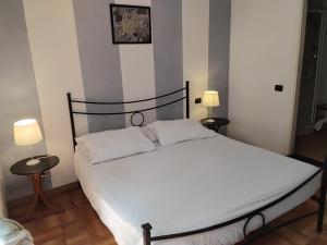 a bedroom with a bed with two tables and two lamps at B&B Fattore in Levanto
