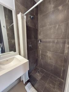 ein Badezimmer mit Dusche, Waschbecken und Spiegel in der Unterkunft Vive Place in Aguascalientes
