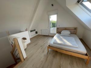 a bedroom with a bed in a attic with a window at Maison avec accès piscine partagée in Colmar
