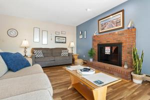 a living room with a couch and a fireplace at Serene waterfront home w/ a dock, large deck & amazing views! in Dyer Cove