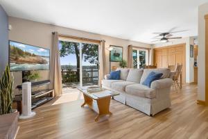 a living room with a couch and a tv at Serene waterfront home w/ a dock, large deck & amazing views! in Dyer Cove