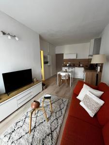 a living room with a red couch and a tv at Céret hyper centre - Cozy T2 in Céret