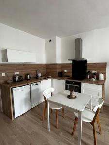 a kitchen with a table and a white table and chairs at Céret hyper centre - Cozy T2 in Céret