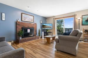 a living room with two chairs and a fireplace at Serene waterfront home w/ a dock, large deck & amazing views! in Dyer Cove +41 photos