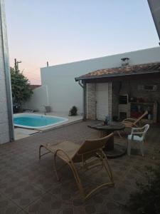a patio with a table and chairs and a pool at momento de paz in Sumaré