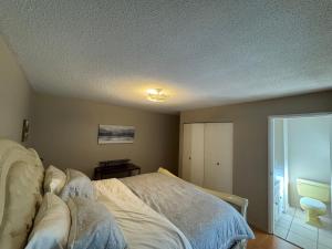 a bedroom with a bed and a sliding glass door at Cozy nest in Coquitlam +8 photos