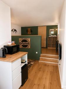 a room with a kitchen with a microwave and stairs at Studio élégant et indépendant Centre ville - Quartier facultés in Nantes