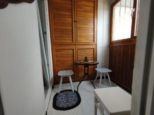 a hallway with two stools and a table and a door at Sky Vista in Železnička Stanica Tuzla