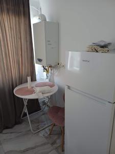 a kitchen with a table and a white refrigerator at Ibo in Brăila