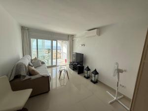 a living room with a couch and a television at AwayDays - 72 - Ocean View Studio in Empuriabrava