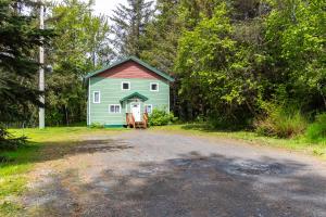 a green barn with a red roof on a dirt road at Alaska Adventures Lodge in Seward