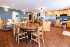 a kitchen and living room with a wooden table and chairs at Alaska Adventures Lodge in Seward