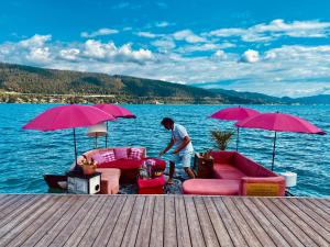 a man standing on a dock next to the water at EinBaumHaus Wörthersee in Auen