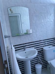 a bathroom with a sink and a mirror and a toilet at Hotel Rama in Oued Laou +38 photos