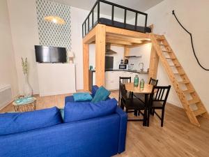 a living room with a blue couch and a loft bed at Le Notre Dame - Hyper centre in Angoulême