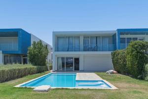 a house with a swimming pool in front of it at Fouka Bay Holiday Apartments By BlueKeys in Marsa Matruh