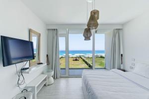 a bedroom with a bed and a large window with the ocean at Fouka Bay Holiday Apartments By BlueKeys in Marsa Matruh +50 photos
