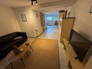 a living room with a black couch and a table at Toms FeWo in Losheim
