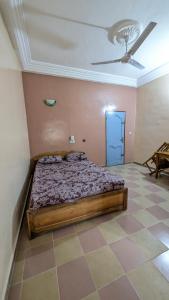 a bedroom with a bed and a ceiling fan at Hôtel St Jo in Bohicon