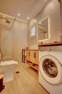 a bathroom with a washing machine and a toilet at Nyfida's four waves in Nifida +65 photos