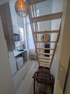 a stairway in a kitchen with a wooden chair at Passage Foch centre historique in Perpignan
