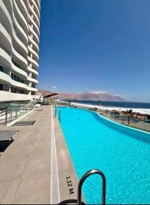a large swimming pool next to a large building at Distrito Cavancha in Iquique