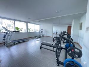 a gym with treadmills and machines in a room at Distrito Cavancha in Iquique