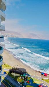 a view of a beach with a playground and the ocean at Distrito Cavancha in Iquique