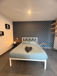 a bedroom with a bed with a blue wall at Foch F1 N7 in Le Creusot
