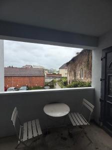 a table and two chairs in a room with a window at Foch F1 N7 in Le Creusot