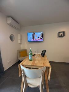 a room with a wooden table and a tv on the wall at Foch F1 N7 in Le Creusot