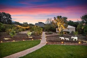 a garden with two white horses in the grass at Bella Luna in Carpinteria