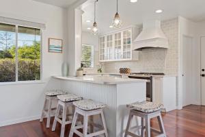 a kitchen with a counter and stools in it at Bella Luna in Carpinteria +34 photos
