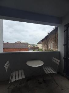 a table and two chairs in a room with a window at Foch F1 N7 in Le Creusot