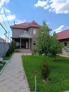 a house with a tree in the yard at BoNa Guest in Bishkek