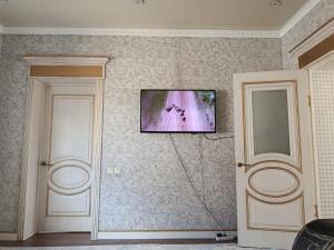 a flat screen tv on the wall of a room at BoNa Guest in Bishkek