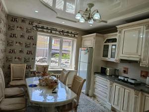 a kitchen with a table and chairs and a refrigerator at BoNa Guest in Bishkek