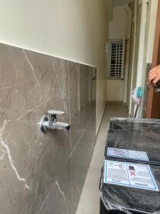a bathroom with a marble wall with a faucet at Narayana Avenue , kondapur 2 Bhk in Hyderabad