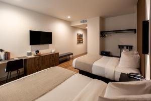 a hotel room with two beds and a flat screen tv at Kins Hotel in Los Angeles