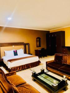 a hotel room with a bed and a couch at Gmasters Boutique Hotel in Kigali +22 photos